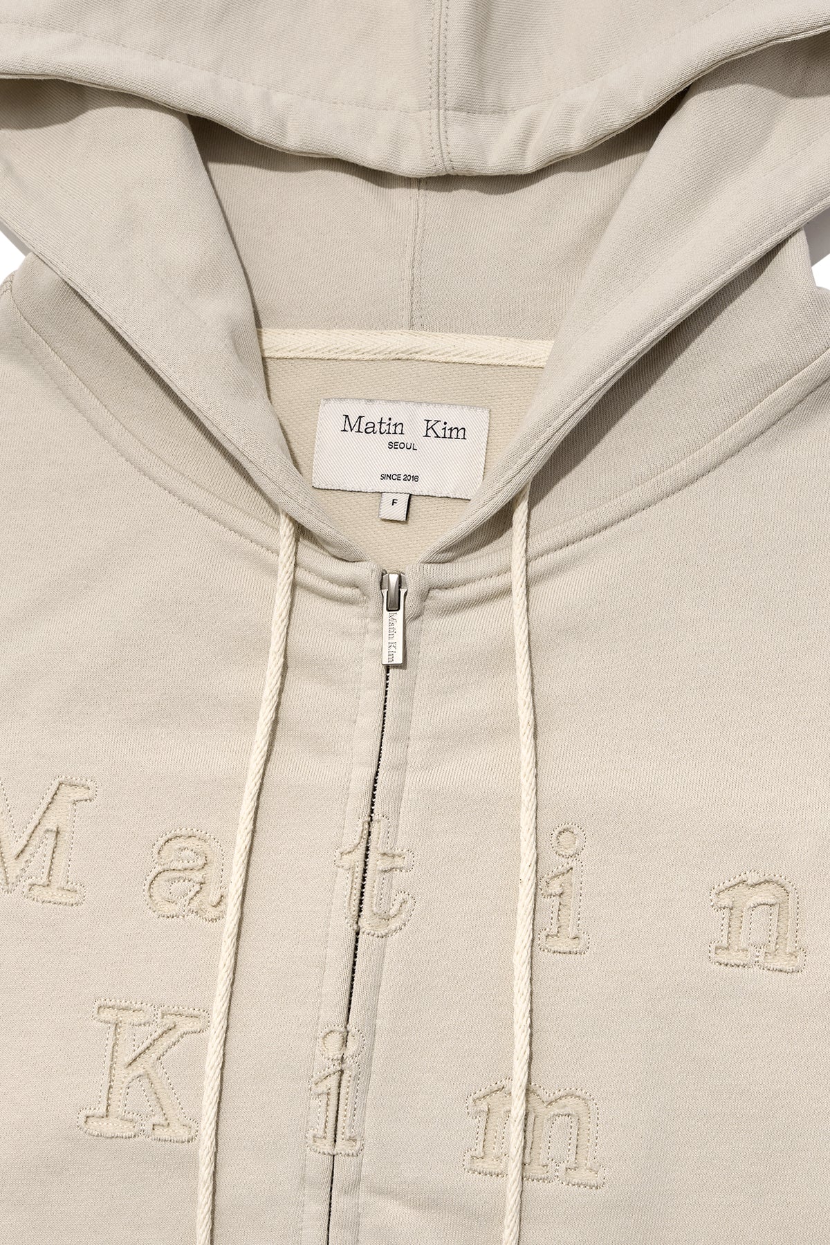 matinkim APPLIQUE CUTTED LOGO HOODY ZIP UP IN BEIGE