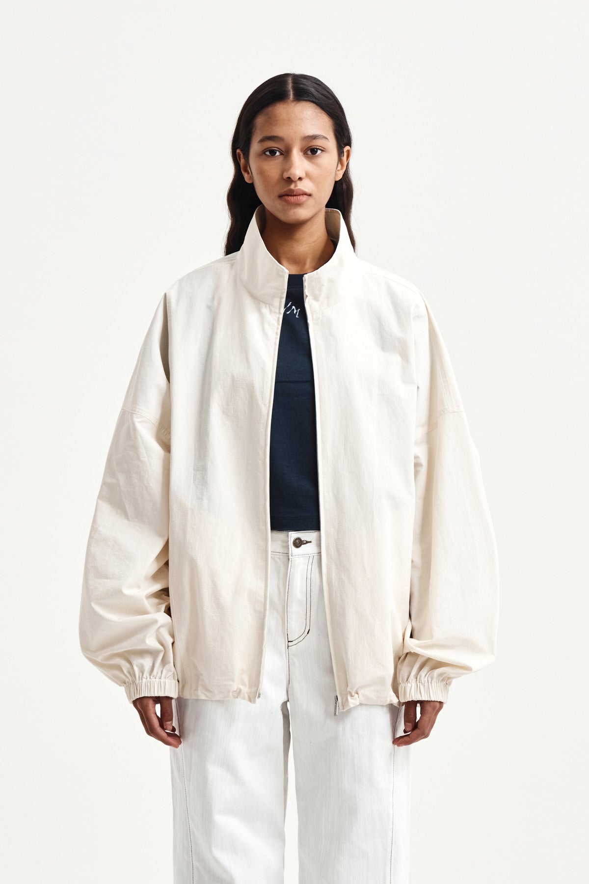 matinkim BACK LOGO HIGH NECK JUMPER IN CREAM